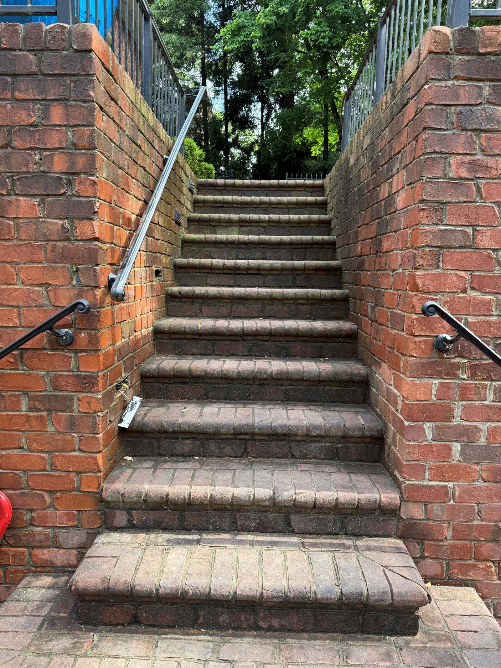 Brick steps with metal handrails before pressure washing