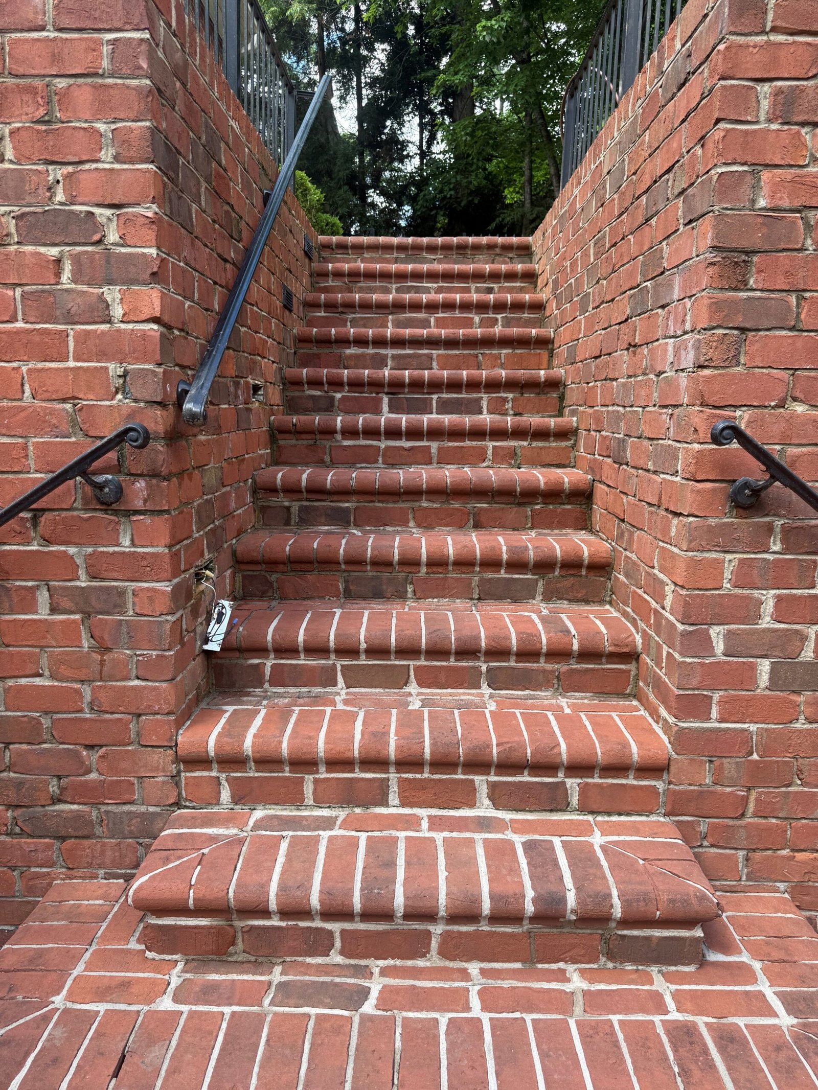 Brick steps with metal handrails after pressure washing